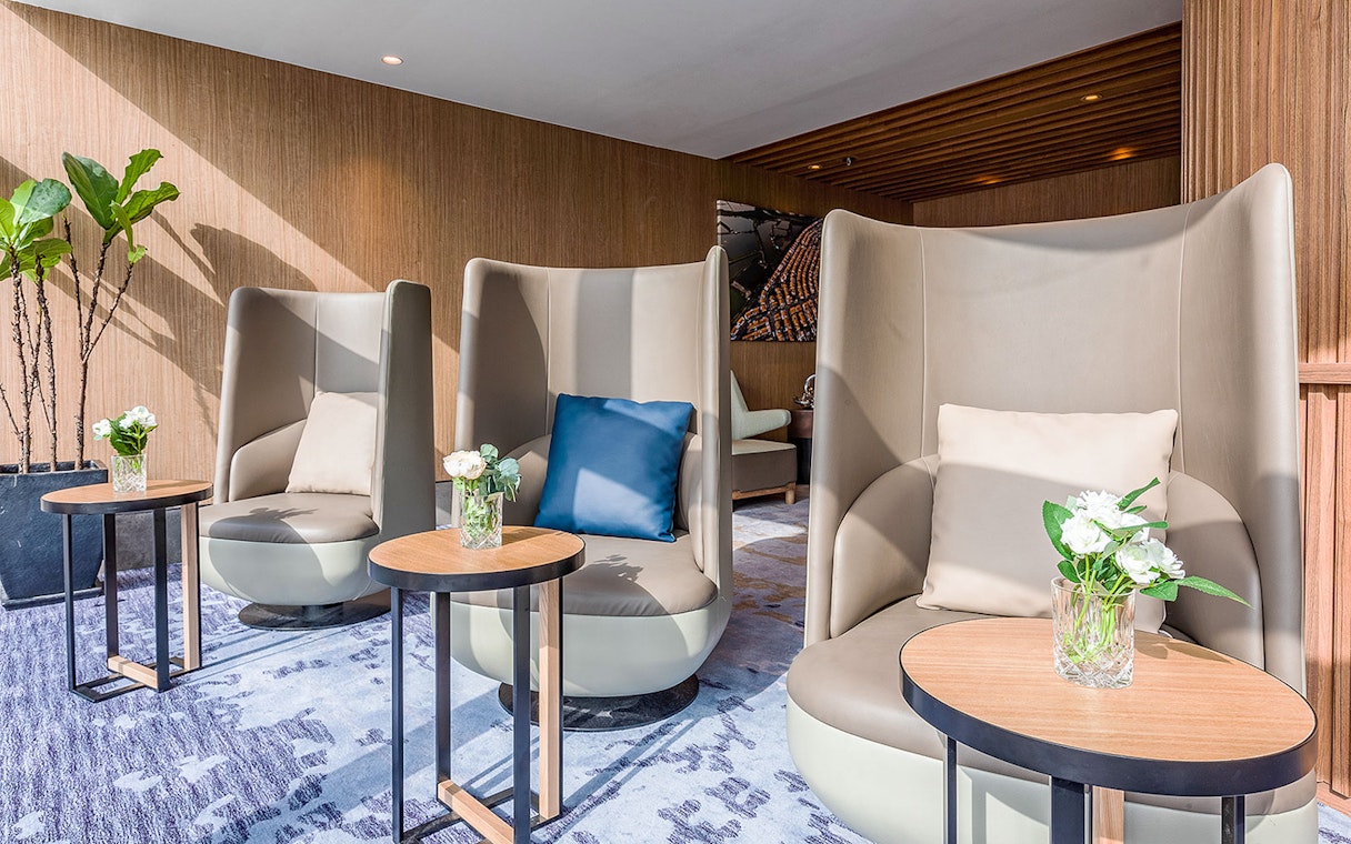 Plaza Premium Lounge seating area with modern chairs and small tables.