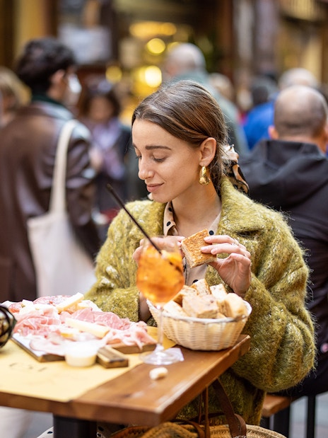 Woman enjoying gourmet street food at an outdoor cafe in Rome.