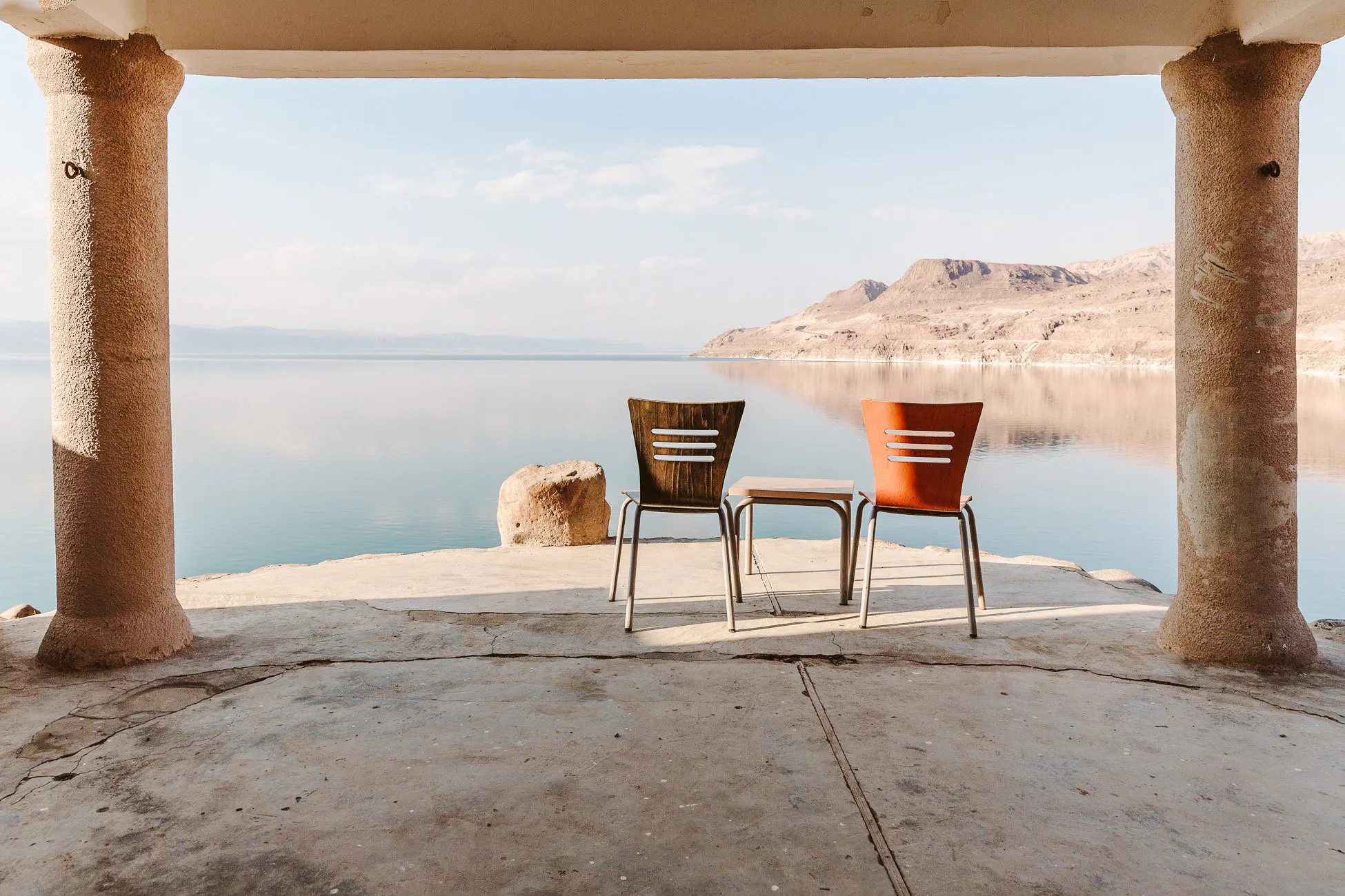 Chairs overlooking the Dead Sea from a shaded terrace, part of Amman to Petra tour.