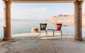 Chairs overlooking the Dead Sea from a shaded terrace, part of Amman to Petra tour.
