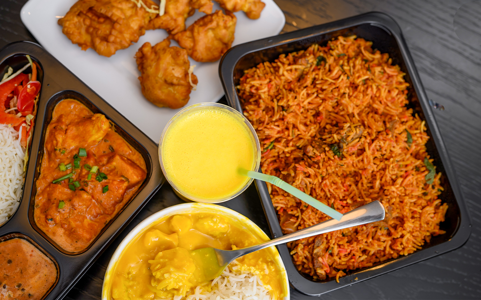 Assorted Indian dishes with curry, rice, and fried snacks on the Brick Lane food tour in London.