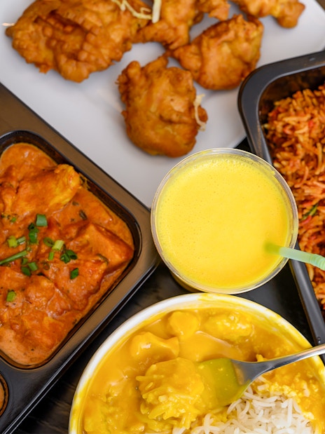 Assorted Indian dishes with curry, rice, and fried snacks on the Brick Lane food tour in London.