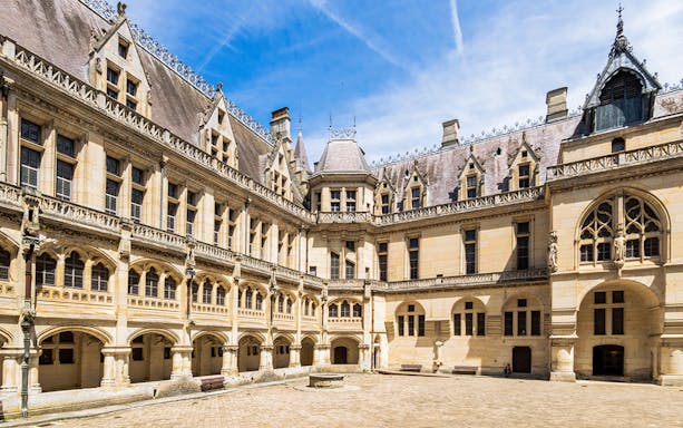 Courtyard of the Castle of Pierrefonds, featuring Gothic architecture and arched windows.