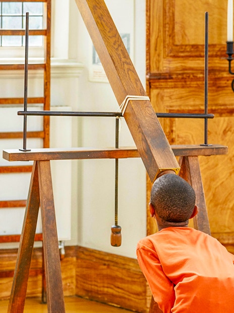 Child observing a historical telescope at Royal Observatory Greenwich.