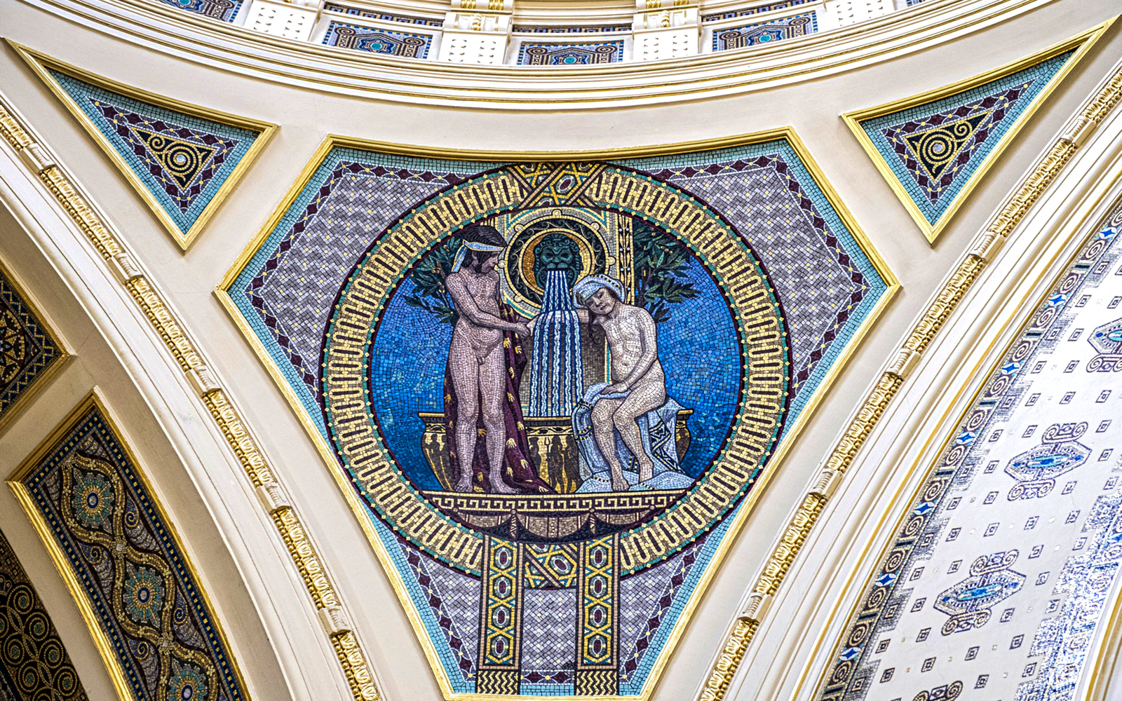 Mosaic artwork on Széchenyi Spa wall, Budapest, depicting classical figures and fountain.