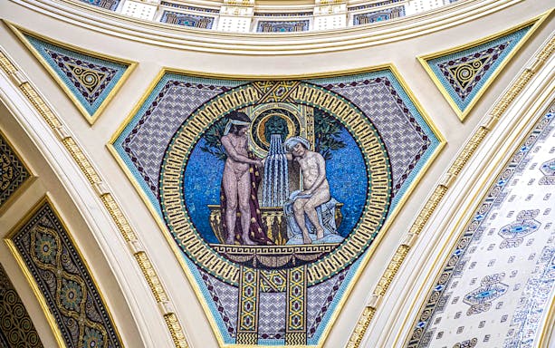 Mosaic artwork on Széchenyi Spa wall, Budapest, depicting classical figures and fountain.