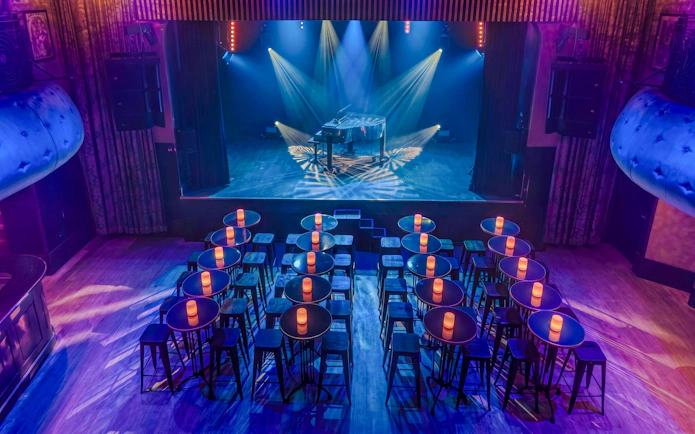 Cabaret stage with piano and seating at Madame Arthur show, Paris.