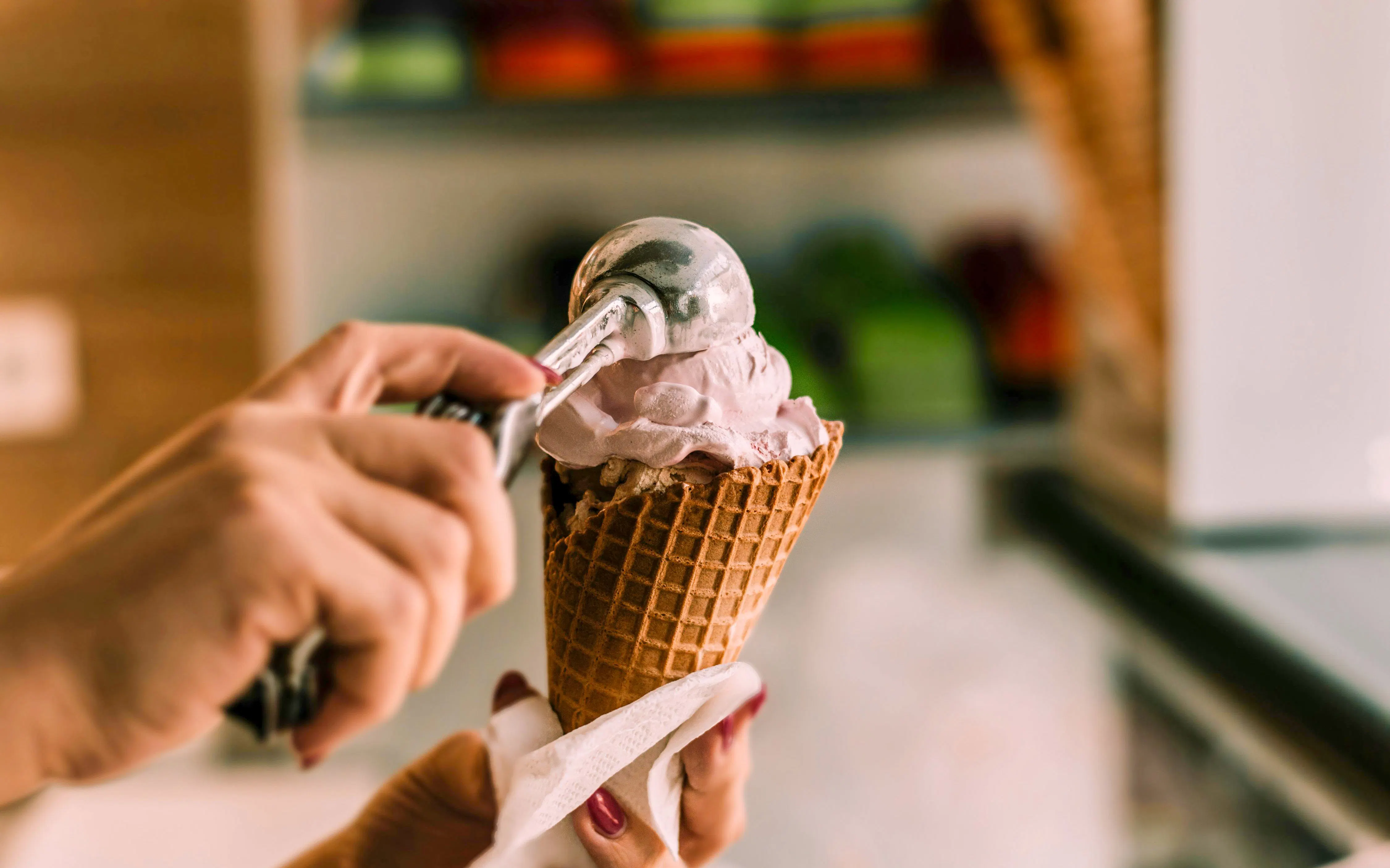 Scooping ice cream into a waffle cone at Berthillon, Paris.