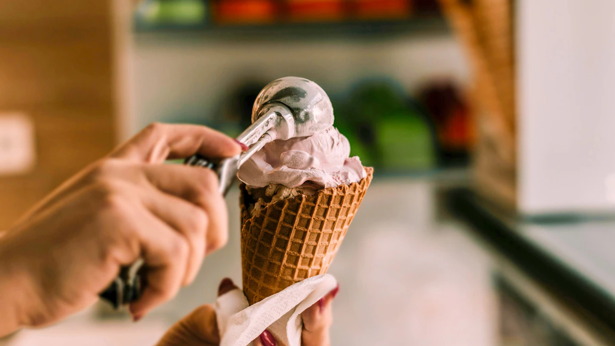 Scooping ice cream into a waffle cone at Berthillon, Paris.