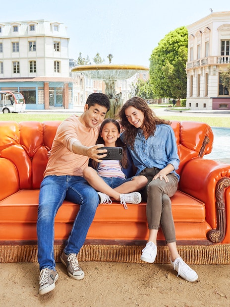 Family taking a selfie on the iconic orange couch at Warner Bros. Studios Hollywood.