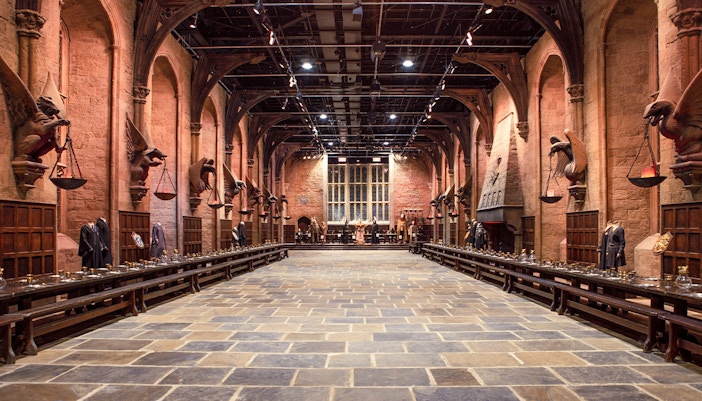 Great Hall set with long tables and costumes during Harry Potter London tour.