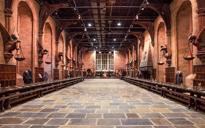 Great Hall set with long tables and costumes during Harry Potter London tour.
