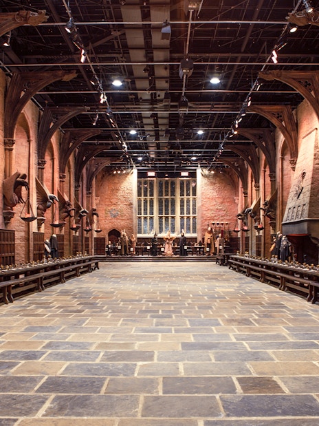 Great Hall set with long tables and costumes during Harry Potter London tour.