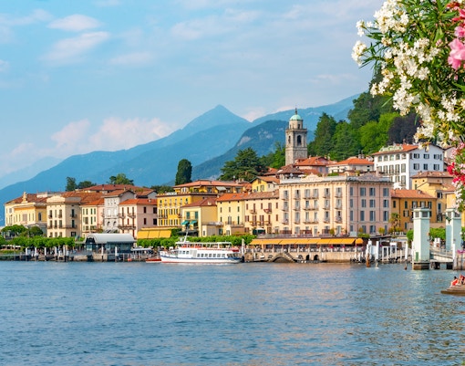 Lakeside view of Bellagio, Italy with colorful buildings and mountains in the background.