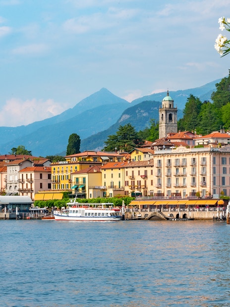 Lakeside view of Bellagio, Italy with colorful buildings and mountains in the background.