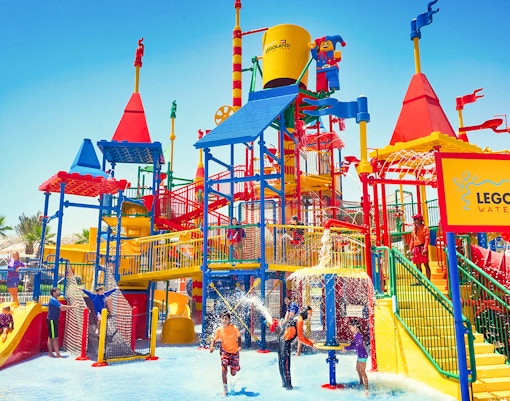 Family at LEGOLAND® Dubai Waterpark enjoying water slides and attractions.