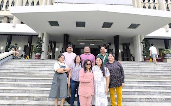 Group visiting historical site in Ho Chi Minh City, standing on steps of a significant building.