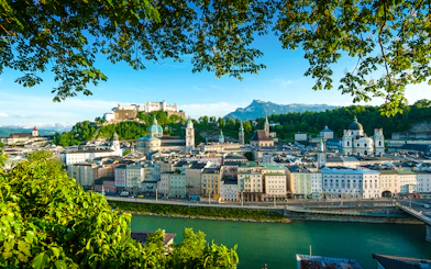 Salzburg cityscape with Hohensalzburg Fortress and Salzach River, view from a hop-on hop-off tour.