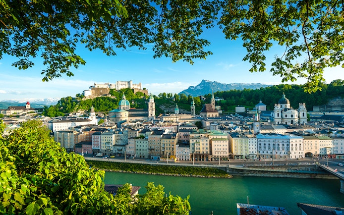 Salzburg cityscape with Hohensalzburg Fortress and Salzach River, view from a hop-on hop-off tour.
