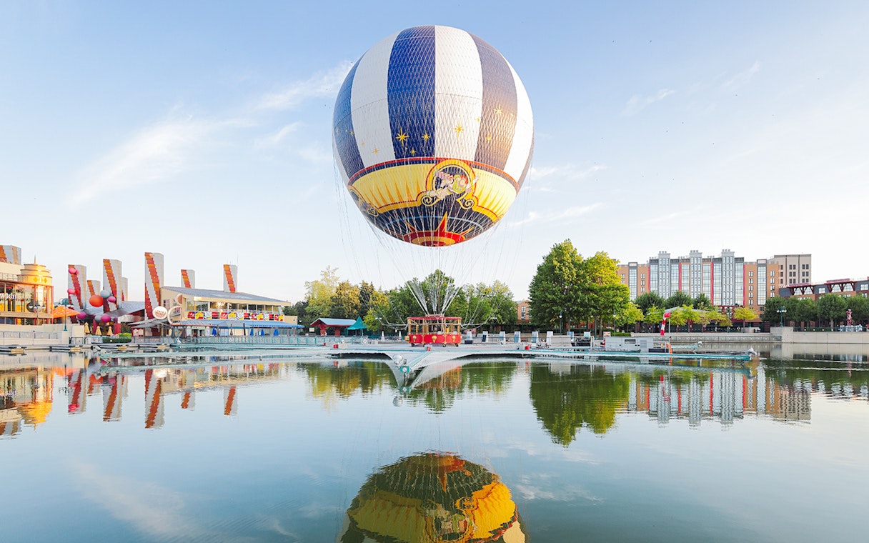 Ballon Panoramagique floating over a reflective lake at Disneyland Paris.