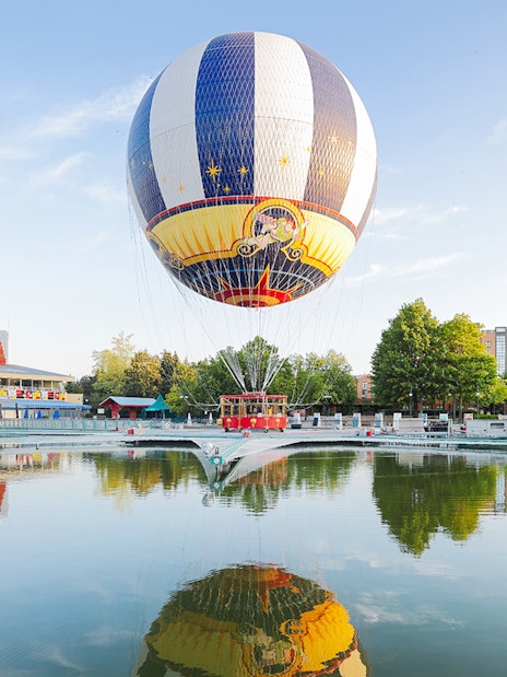 Ballon Panoramagique floating over a reflective lake at Disneyland Paris.