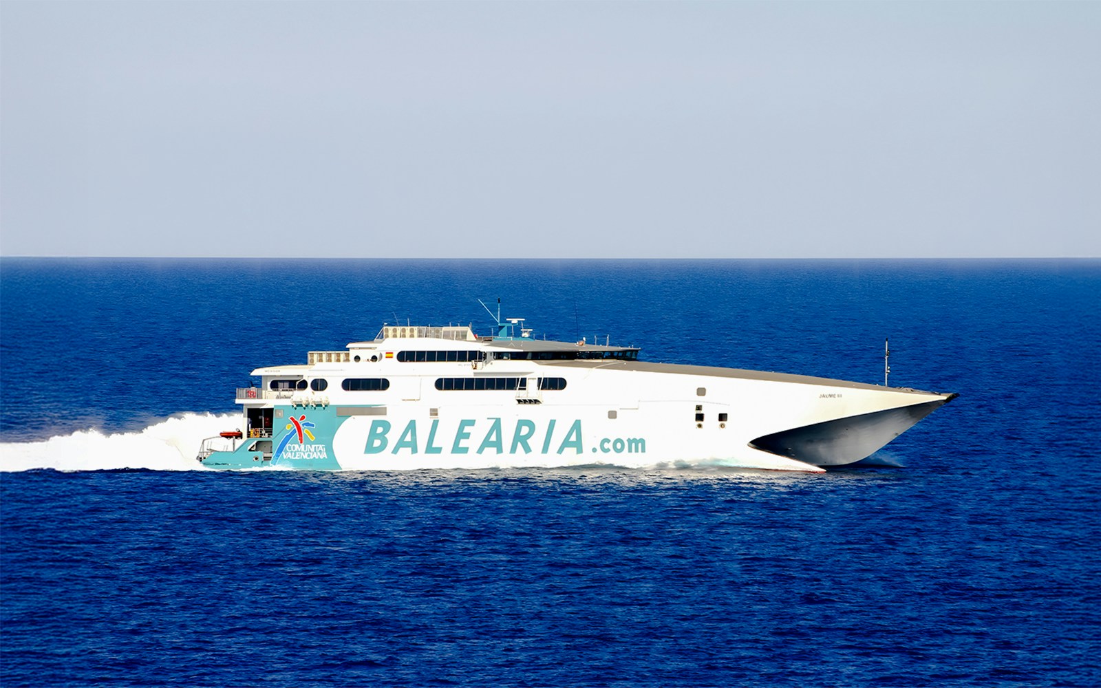 High-speed catamaran ferry sailing from Miami to Bimini, Bahamas, with passengers on deck.
