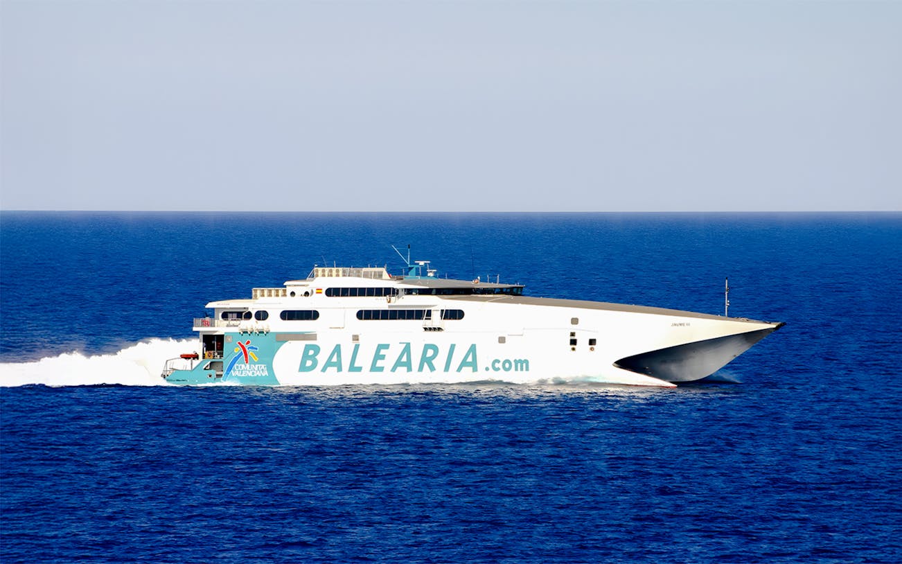 High-speed catamaran ferry sailing from Miami to Bimini, Bahamas, with passengers on deck.