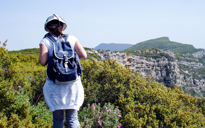 Hiker with backpack on trail at Arrábida Natural Park, Portugal.