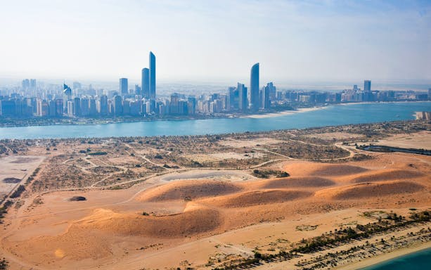 Aerial view of Abu Dhabi skyline and desert during helicopter tour.