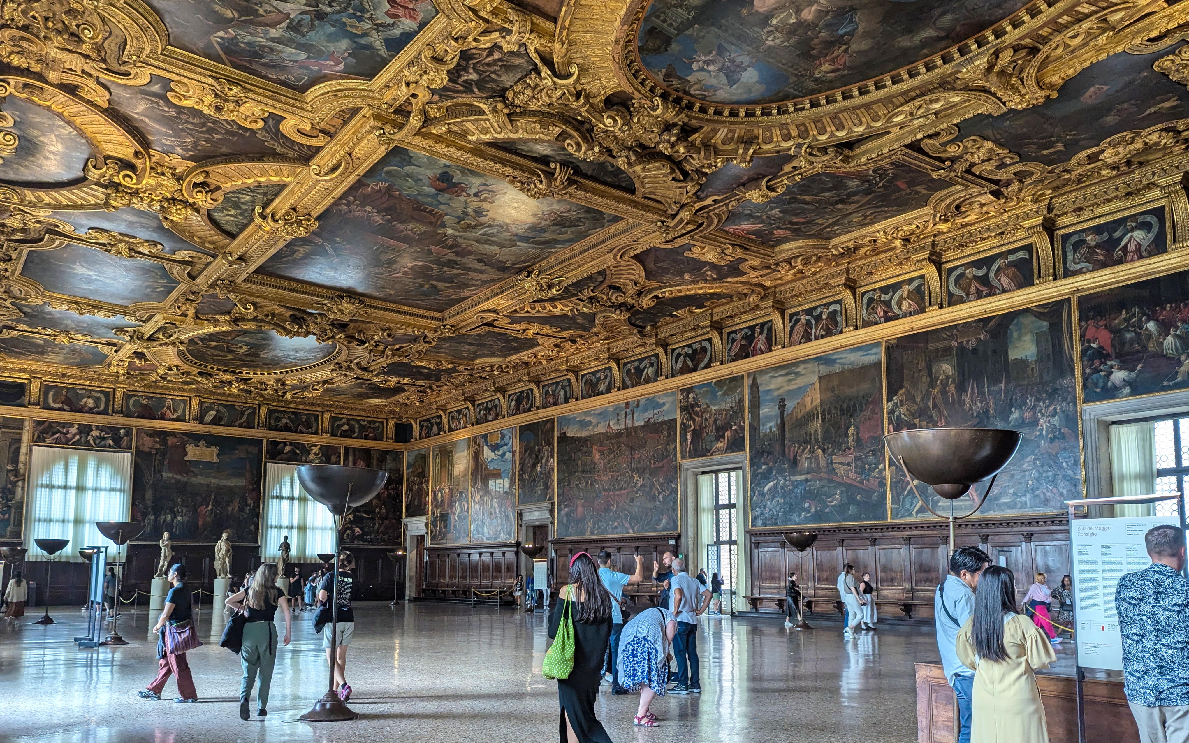 Visitors exploring the ornate interior of the Doge's Palace in Venice.