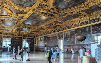 Visitors exploring the ornate interior of the Doge's Palace in Venice.