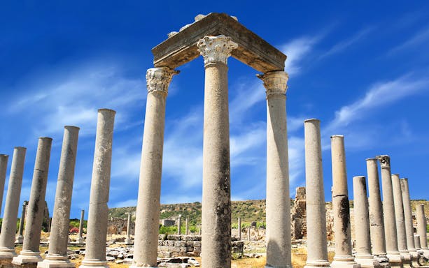Ancient columns at Perge ruins under a clear blue sky, Antalya tour.