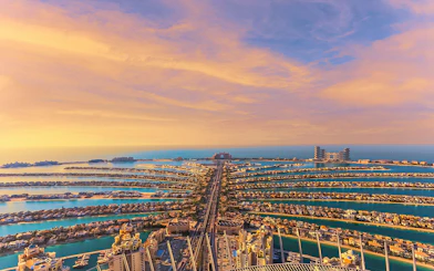 Aerial view of Palm Jumeirah in Dubai at sunset, showcasing the iconic palm-shaped islands.