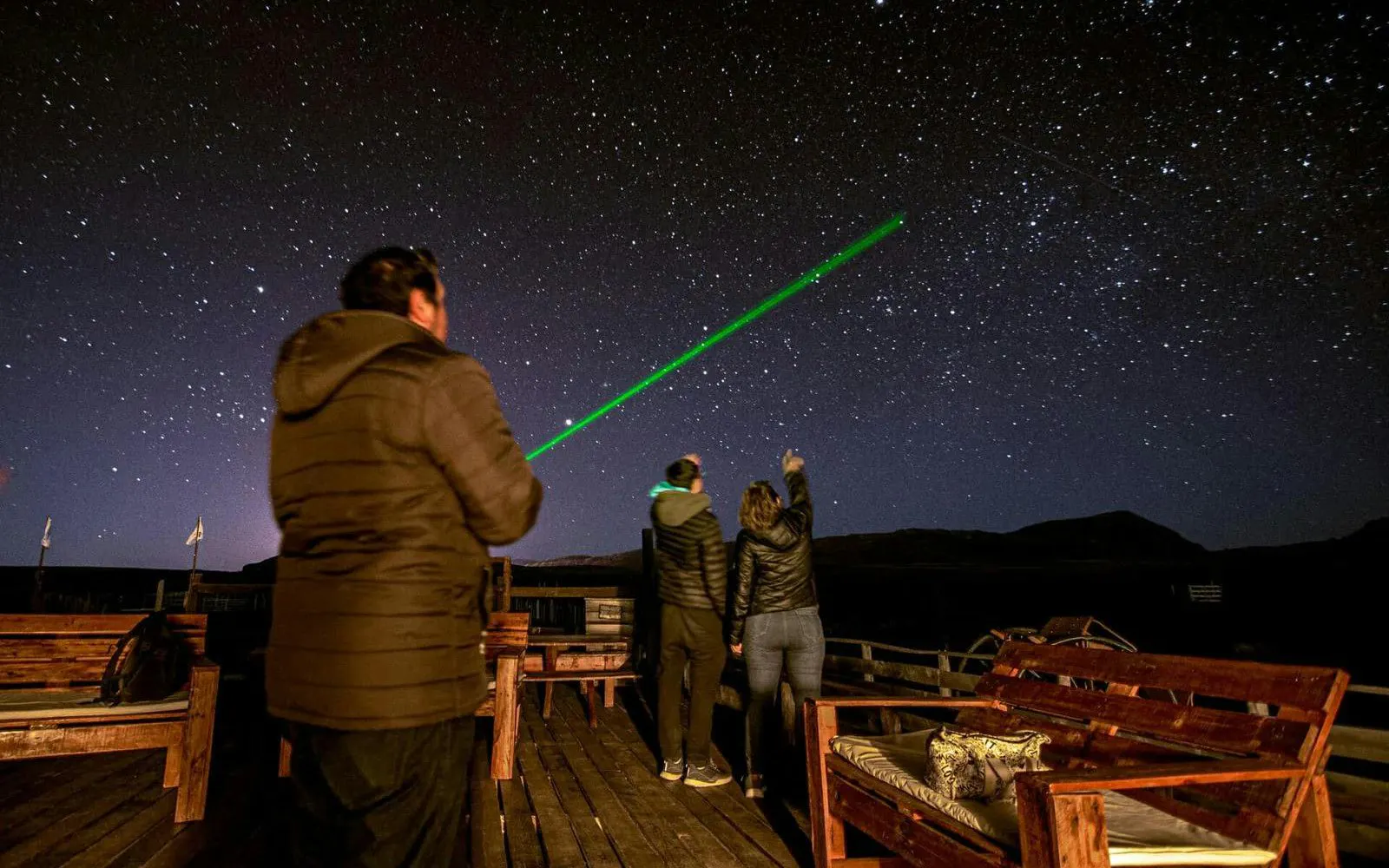 Stargazing tour in Calafate with guide pointing at constellations using a laser pointer.