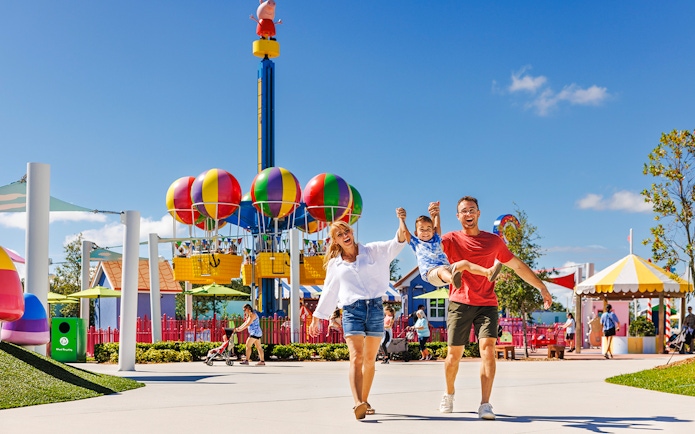 Family enjoying Peppa Pig Theme Park with colorful balloon ride in Florida.