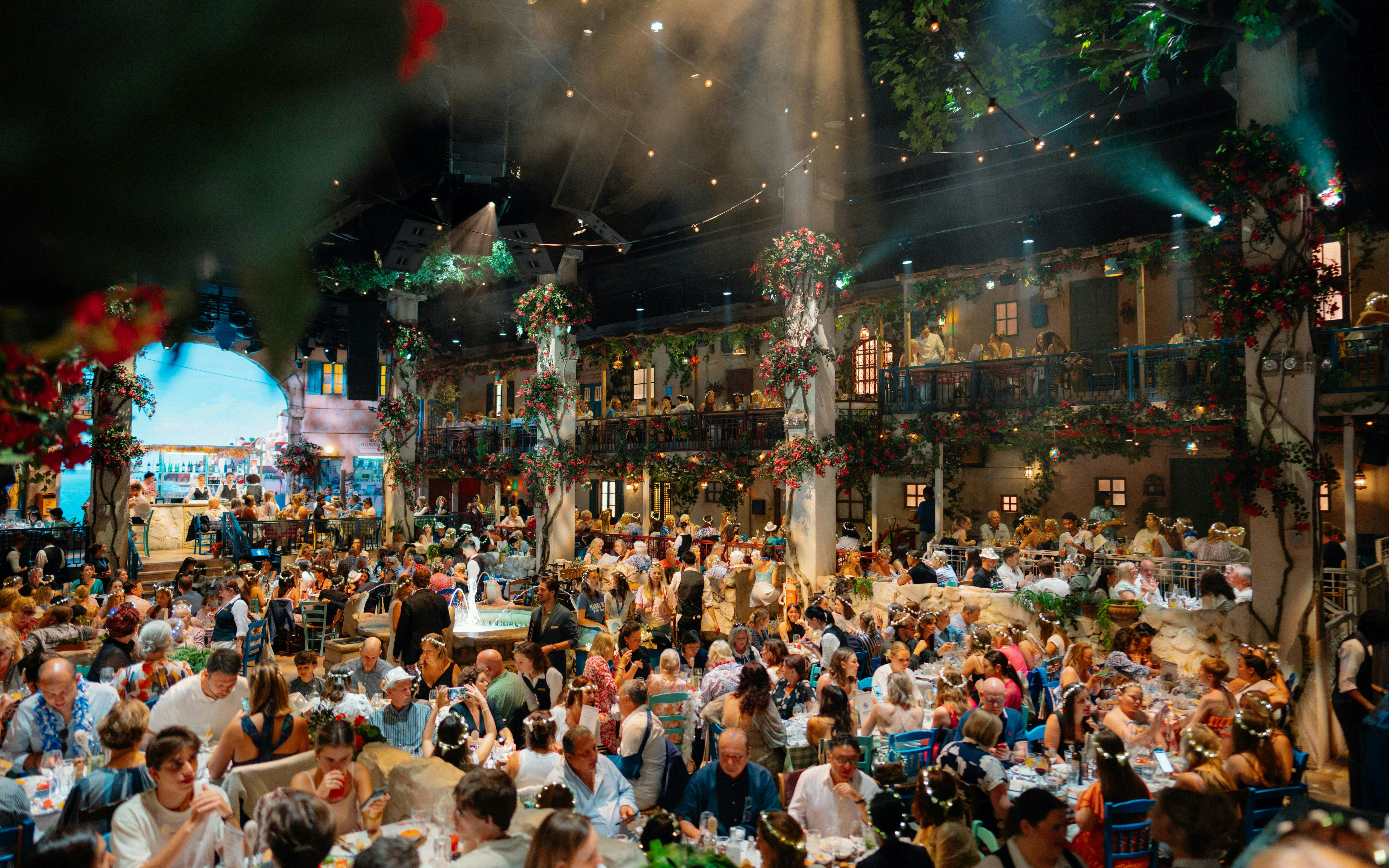 Guests dining at Mamma Mia! The Party with vibrant decor and lively atmosphere.