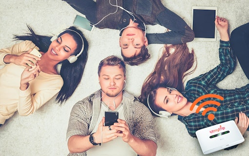 Group using smartphones and tablets with 4G Pocket WiFi rental at DXB/AUH/SHJ airport.