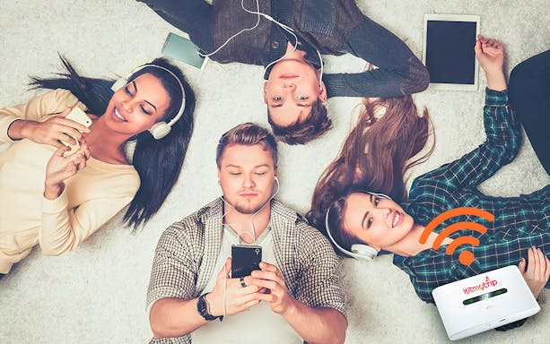 Group using smartphones and tablets with 4G Pocket WiFi rental at DXB/AUH/SHJ airport.