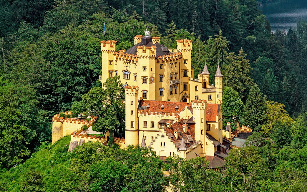 Hohenschwangau Castle surrounded by lush forest, Bavaria, Germany.