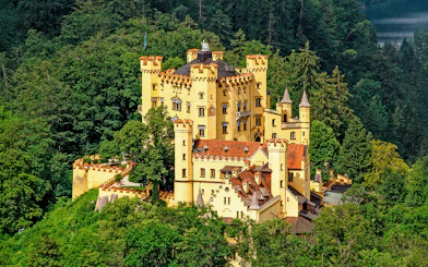 Hohenschwangau Castle surrounded by lush forest, Bavaria, Germany.
