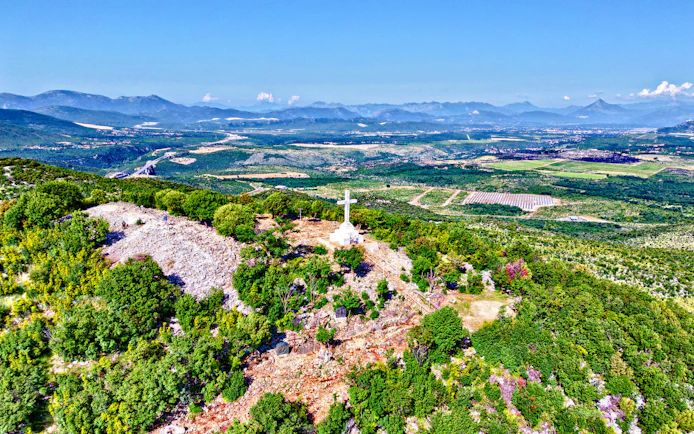Mount Križevac cross overlooking Medjugorje landscape in Bosnia and Herzegovina.