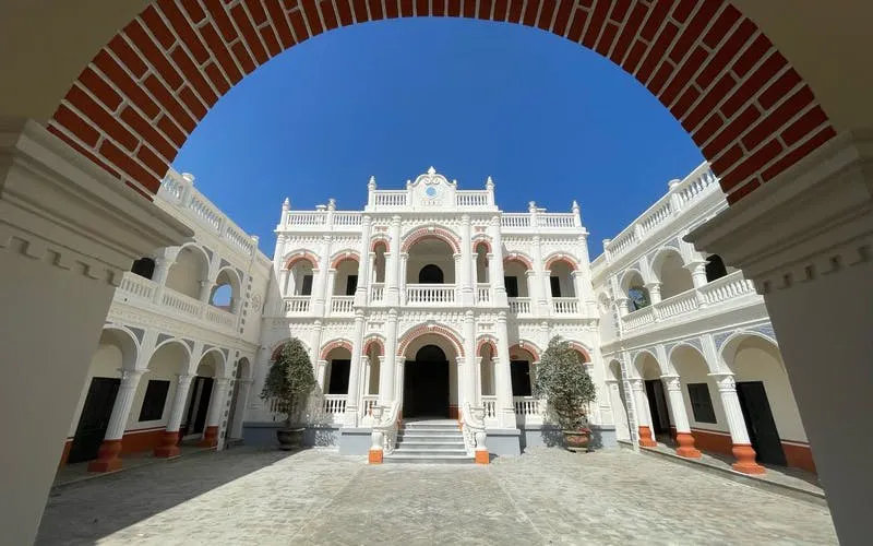 Courtyard of a historic building with arches in Bac Ha Market area, Vietnam.