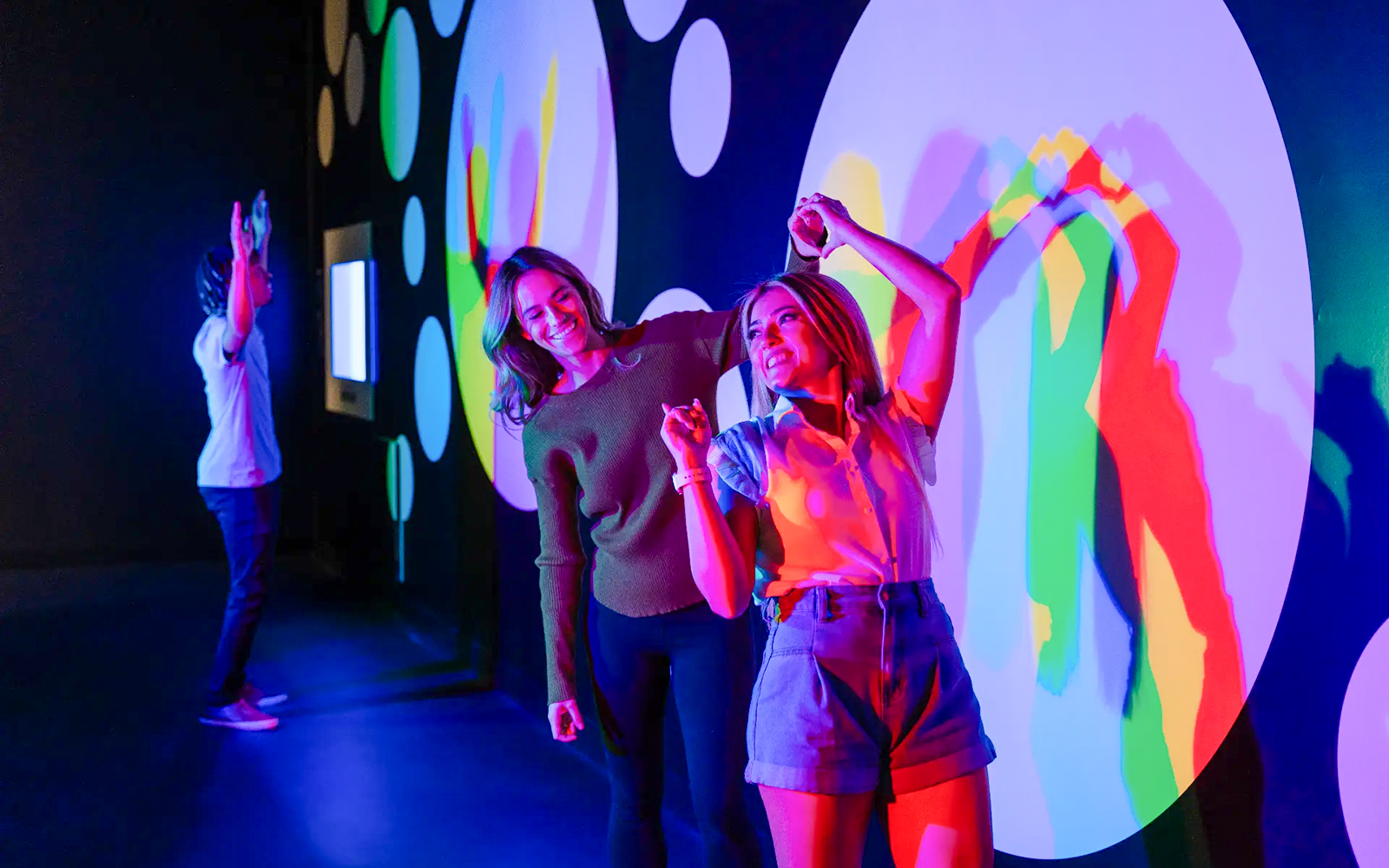 Visitors interacting with colorful light displays at Paradox Museum Paris.