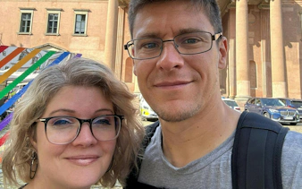Two people in front of a historic building in Copenhagen, part of the Time Travelers Cronophone city exploration game.