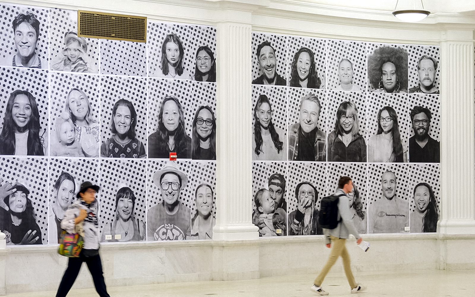 Black and white portraits displayed on a wall, part of "Climate and Health Dreams We Carry" exhibit.