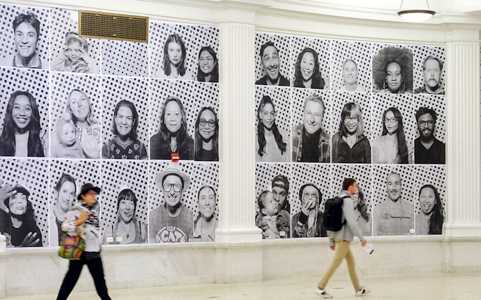 Black and white portraits displayed on a wall, part of "Climate and Health Dreams We Carry" exhibit.