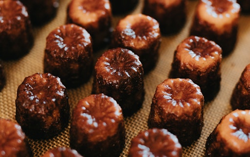 Canelés arranged on a tray for tasting on Bordeaux River Cruise.
