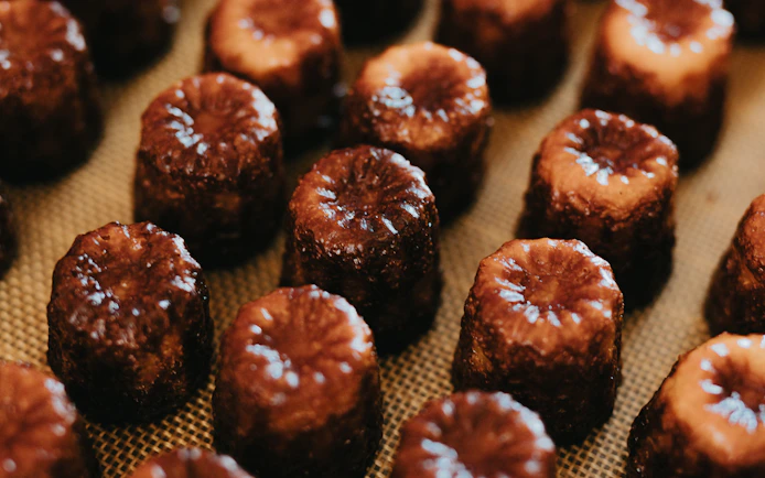 Canelés arranged on a tray for tasting on Bordeaux River Cruise.