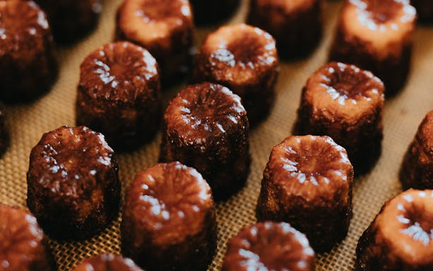 Canelés arranged on a tray for tasting on Bordeaux River Cruise.