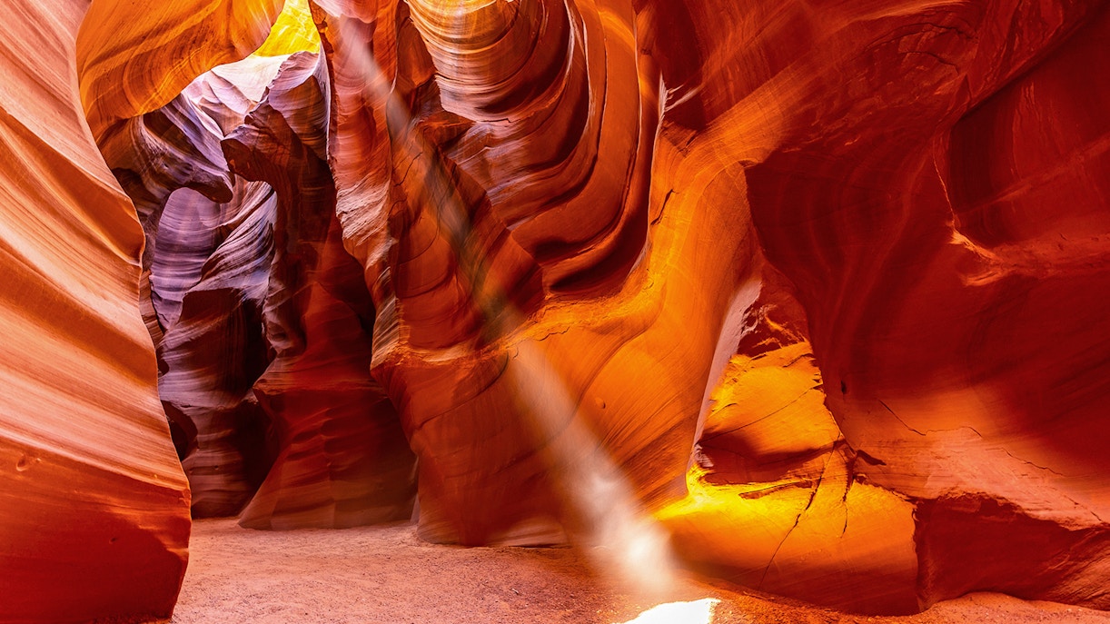 Upper Antelope Canyon sandstone formations with light beams during guided tour in Arizona.